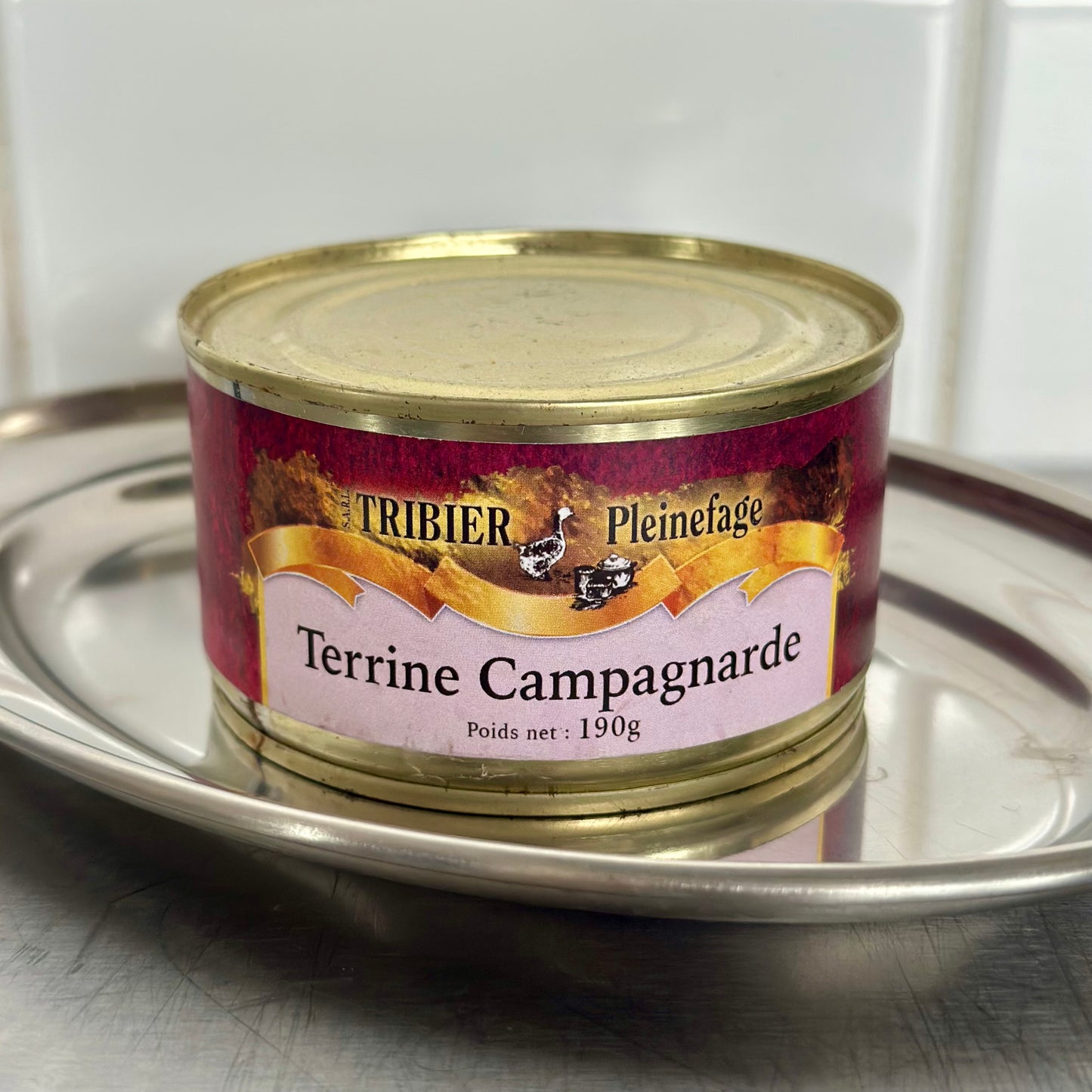 Tin of Terrine Campagnarde by Tribier Pleinefage on a metallic surface