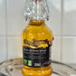 Bottle of walnut oil on a metallic tray with a white tiled background